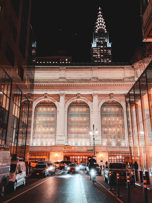 A person's hands holding a notebook with cookie sketches and a plate of cookies on a wooden table